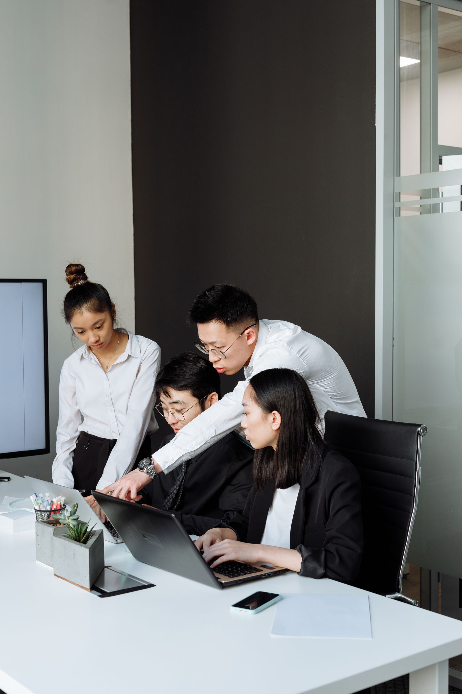 Team of colleagues reviewing options together on laptops in a modern office