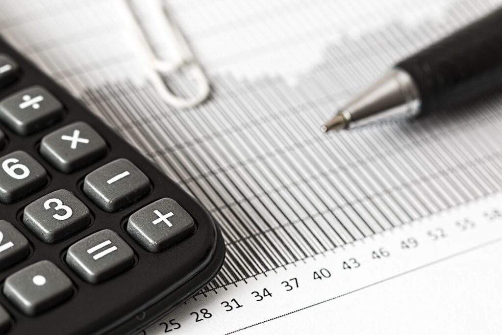 Calculator and pen resting on a financial spreadsheet