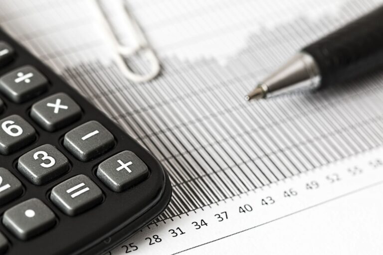 Calculator and pen resting on a financial spreadsheet