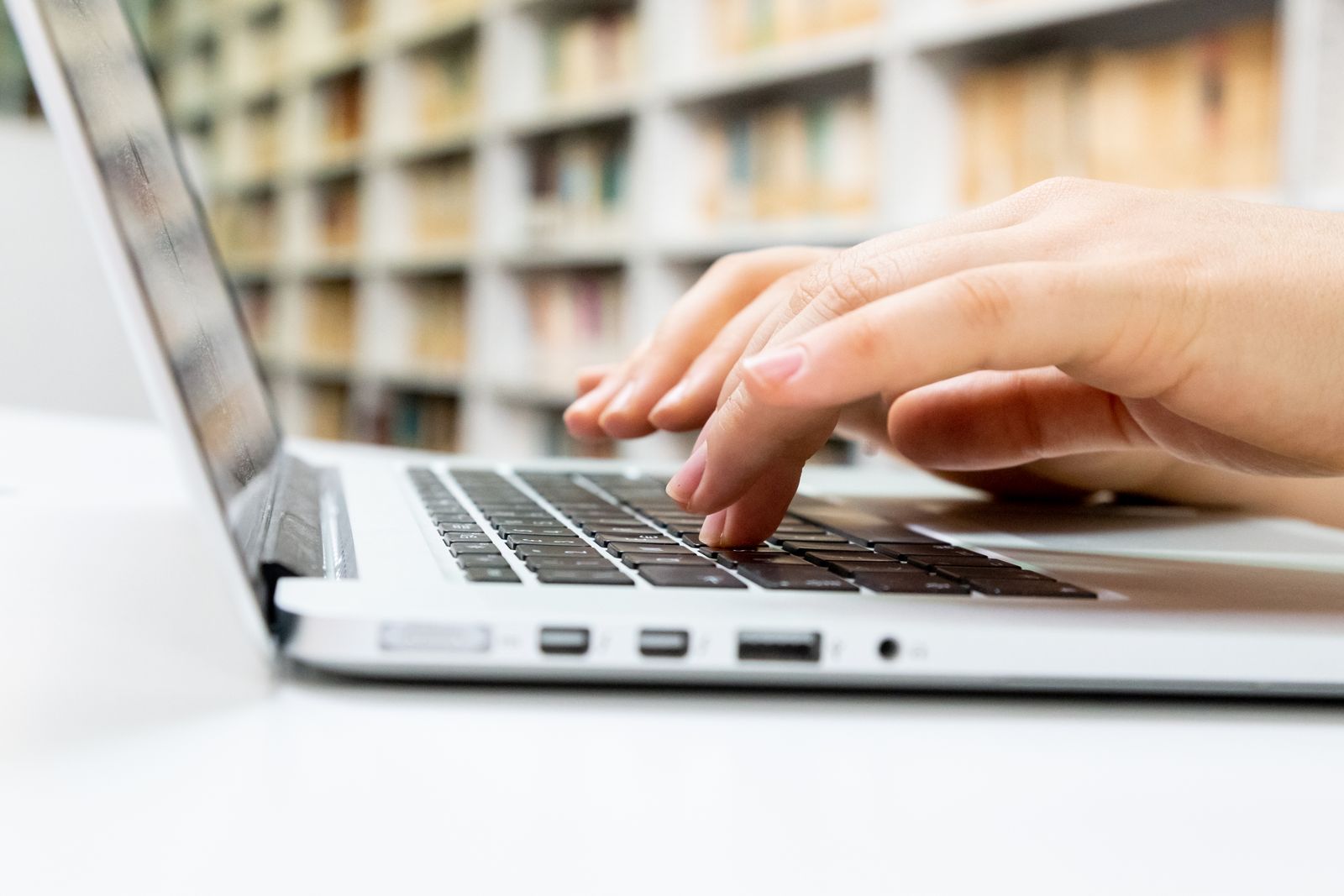 Close-up of hands typing on a laptop keyboard